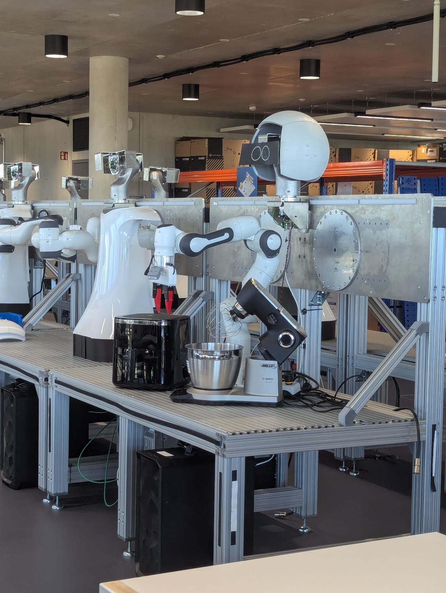 Franka Emika arms next to the BSH smart kitchen appliances used at the hackathon.